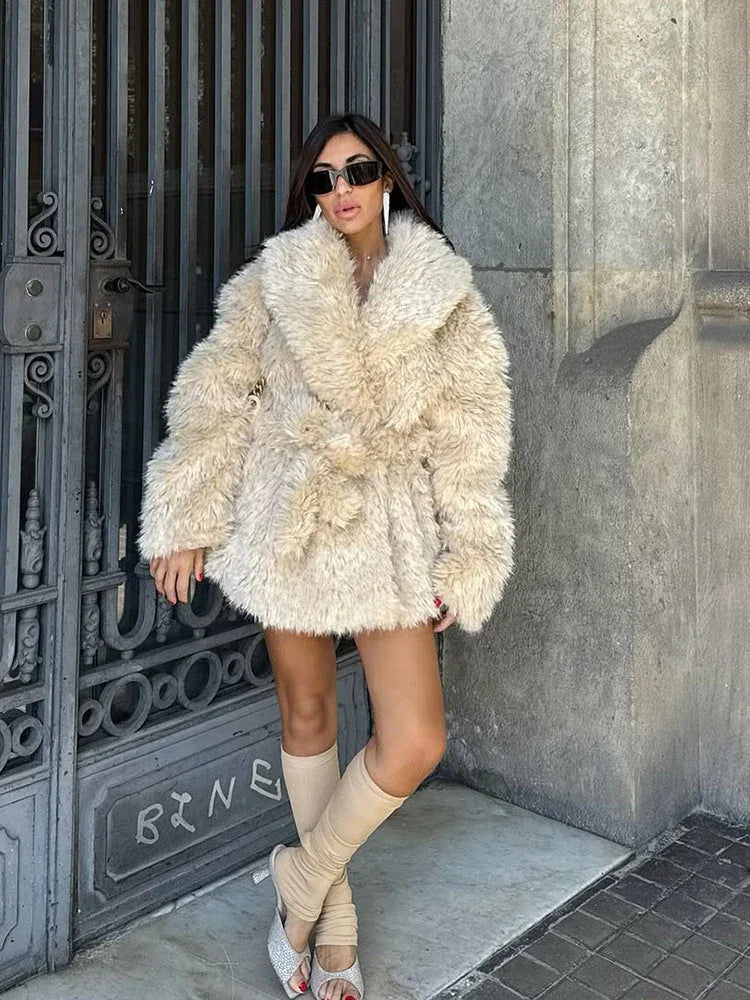 Woman posing in a cream faux fur jacket, highlighting the garment's silhouette and material.