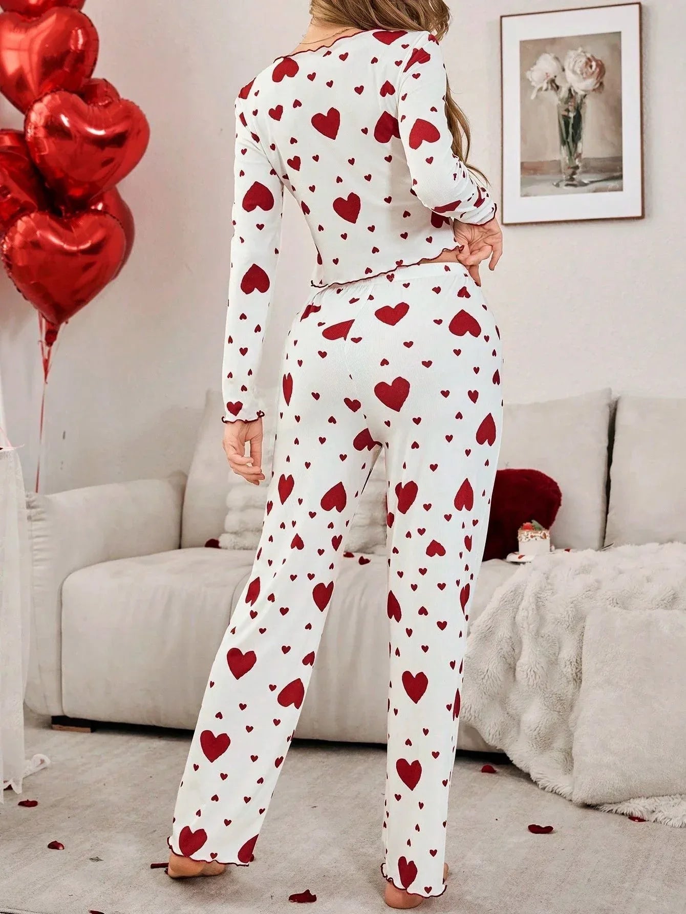 Rear view of a woman in white pajamas with a red heart pattern.
