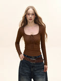 Woman wearing a brown long-sleeve ribbed knit top with a tie-front detail and scoop neckline.