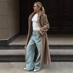 Woman wearing a long brown faux fur coat, white t-shirt, and light blue wide-leg jeans.