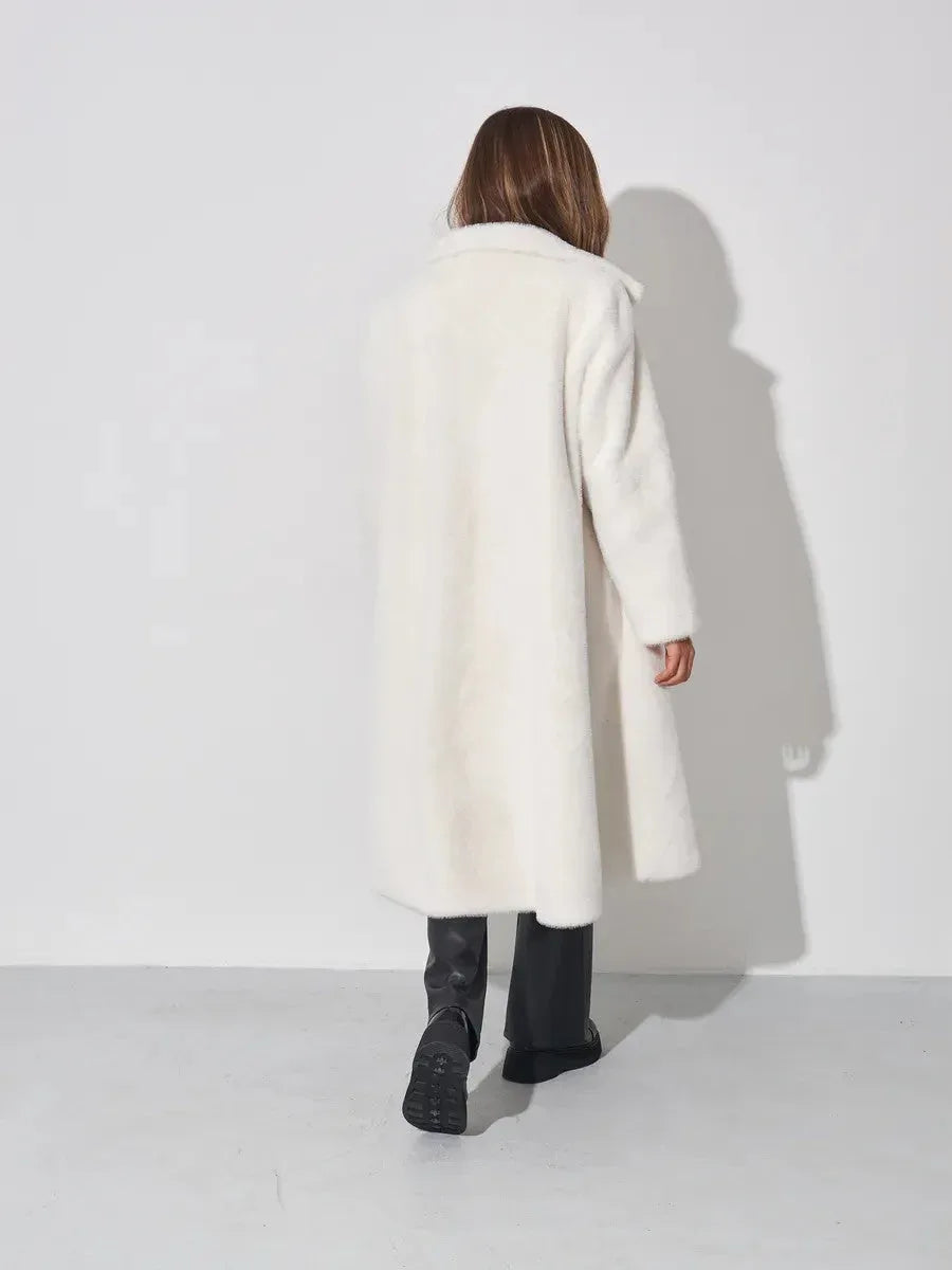 Back view of a woman in a white faux fur long coat.