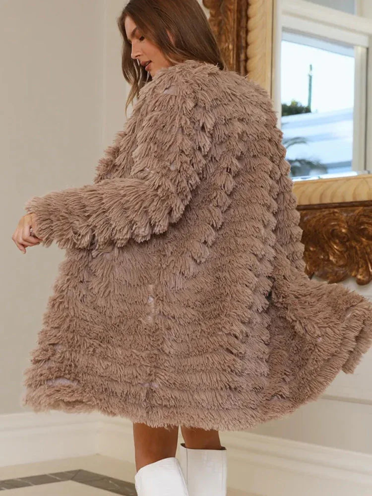 Woman in a tan shaggy faux fur jacket, turning to the side, showing the back of the jacket.