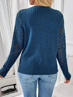 Back view of a woman in a blue knit sweater with openwork sleeves