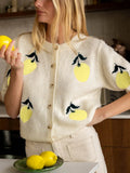 Close-up of a cream knit cardigan with a lemon print