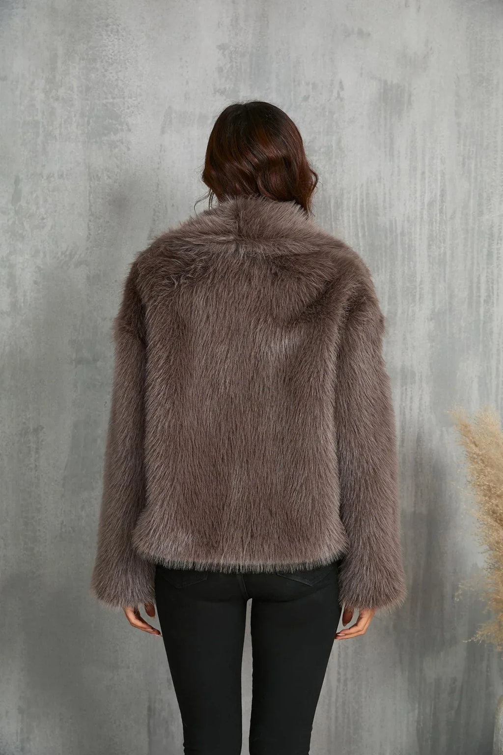 Back view of a woman in a brown faux fur cropped jacket