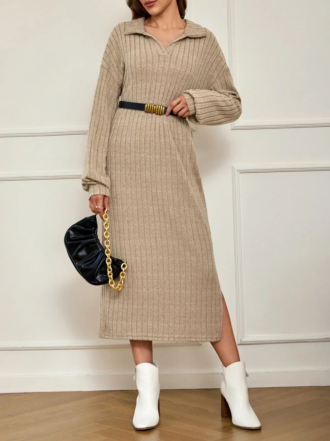 Woman accessorizing a beige ribbed knit maxi dress with a belt