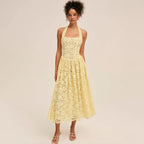 Woman wearing a yellow lace halter midi dress, front view