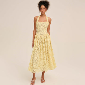 Woman wearing a yellow lace dress against a beige background