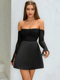 Front view of a woman in a black off-the-shoulder dress with ruched detail and sheer sleeves