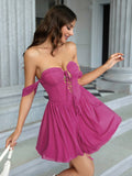Woman in a fuchsia off-the-shoulder dress with a sweetheart neckline and lace-up detail