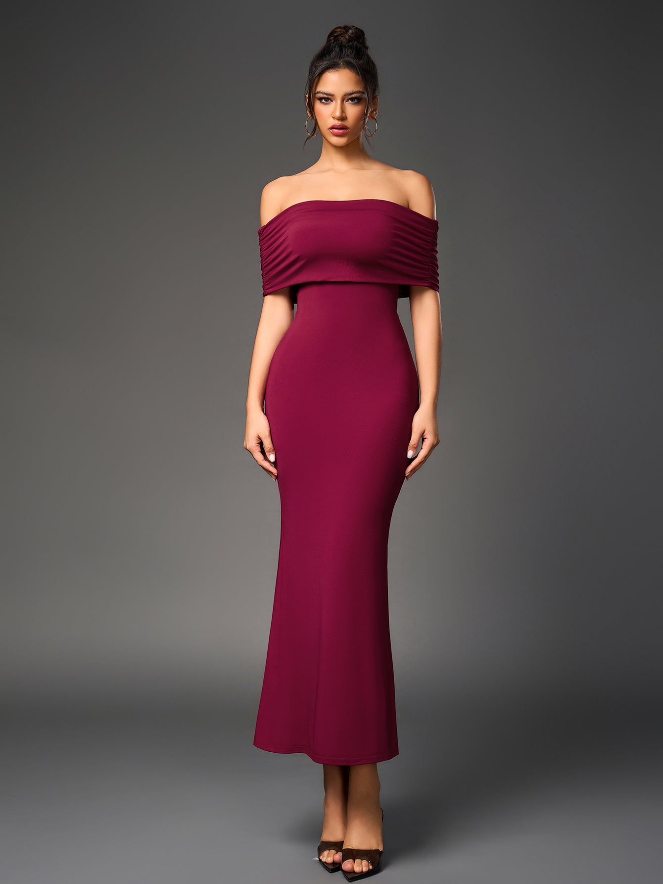 Woman wearing a floor-length, off-the-shoulder maroon dress with ruched detailing on the back.