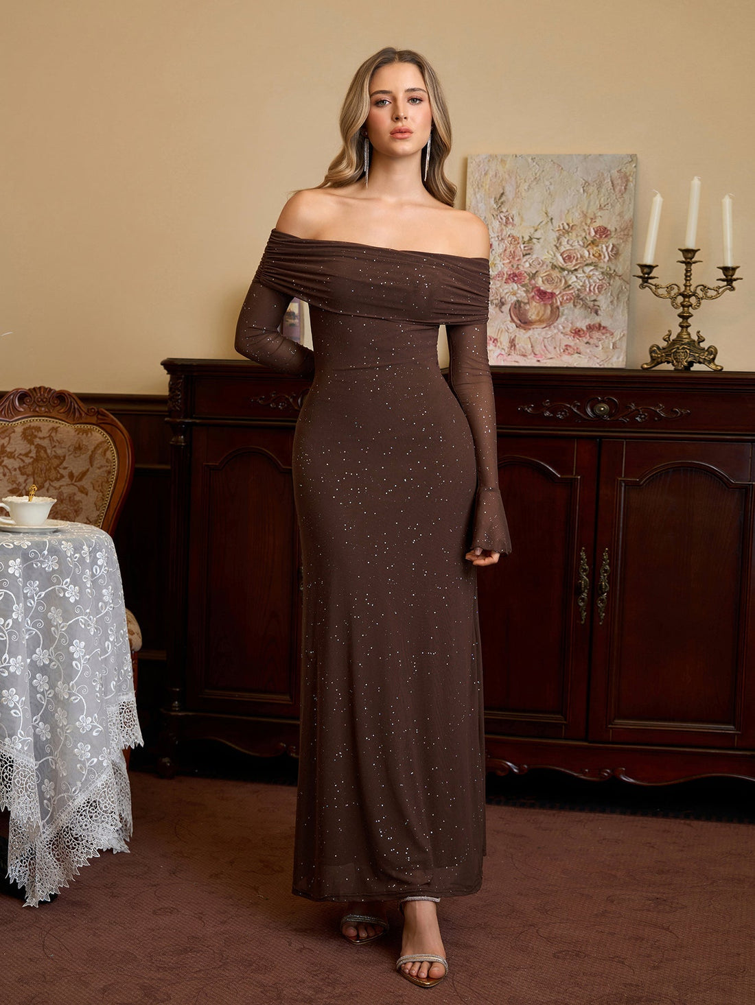 Woman wearing a long brown off-the-shoulder dress with sparkling details