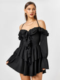 Woman wearing a black off-the-shoulder dress with ruffle details and a halter neck.