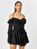 Front view of a woman modeling a black ruffled dress with off-the-shoulder long sleeves.