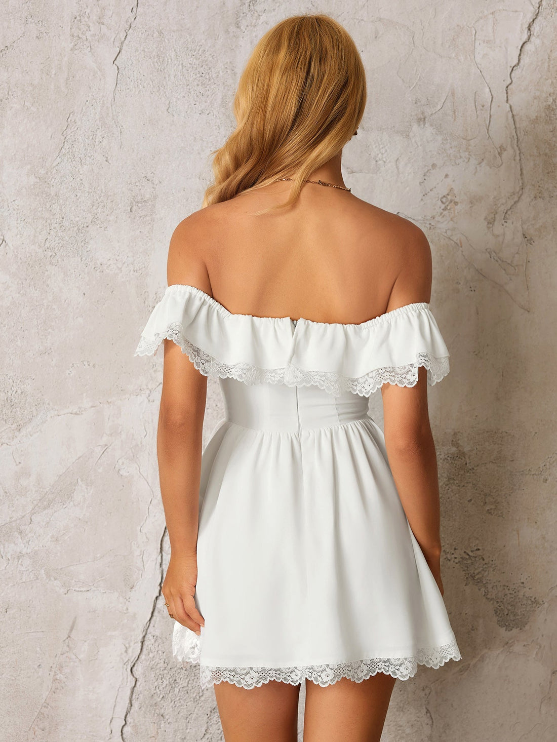 Woman wearing a white off-the-shoulder dress with ruffled and lace trim, and a large bow detail on the front.