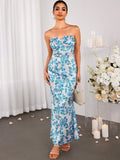 A woman models a strapless floral maxi dress with a mermaid silhouette, paired with minimalist sandals and drop earrings.