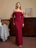 Woman in a red sparkle mermaid gown with off-the-shoulder long sleeves posing.