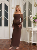 Woman posing in a long brown off-the-shoulder ruched dress with sheer details