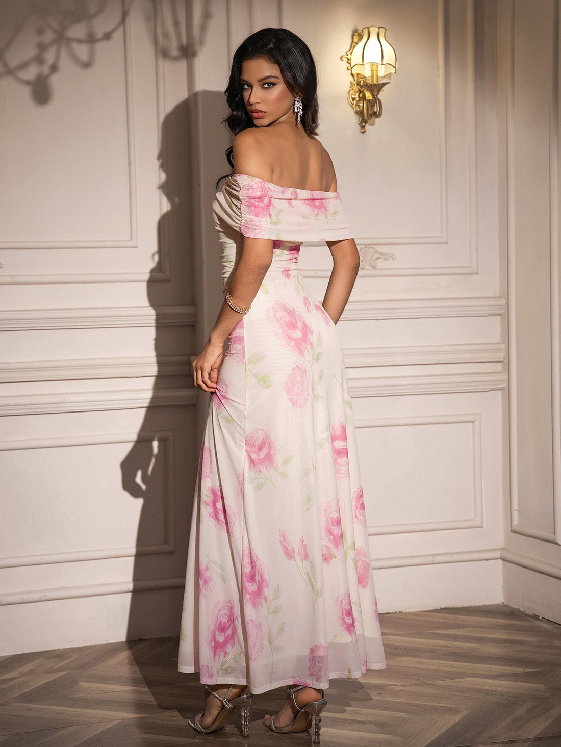 Woman wearing a white off-the-shoulder maxi dress with a pink floral print.