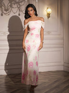 Full length shot of a woman in a white off-the-shoulder maxi dress with a pink floral print.