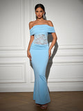 Front view of a woman in a flowing light blue evening gown featuring an off-the-shoulder design and delicate lace accents.