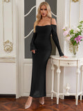 Woman posing in a black formal gown with off-the-shoulder long sleeves.