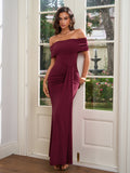 Woman posing in a burgundy off-the-shoulder formal dress with ruched details.