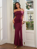 Full-length shot of a woman in a burgundy off-the-shoulder mermaid dress with an asymmetrical drape.