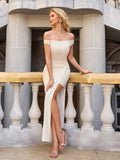 Woman in a cream off-the-shoulder evening gown with a high slit looking to the side