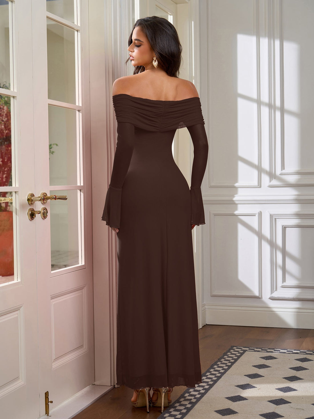 Woman wearing a long brown off-the-shoulder dress with flared sleeves