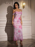 Full body shot of a woman in a formal pink floral print dress.