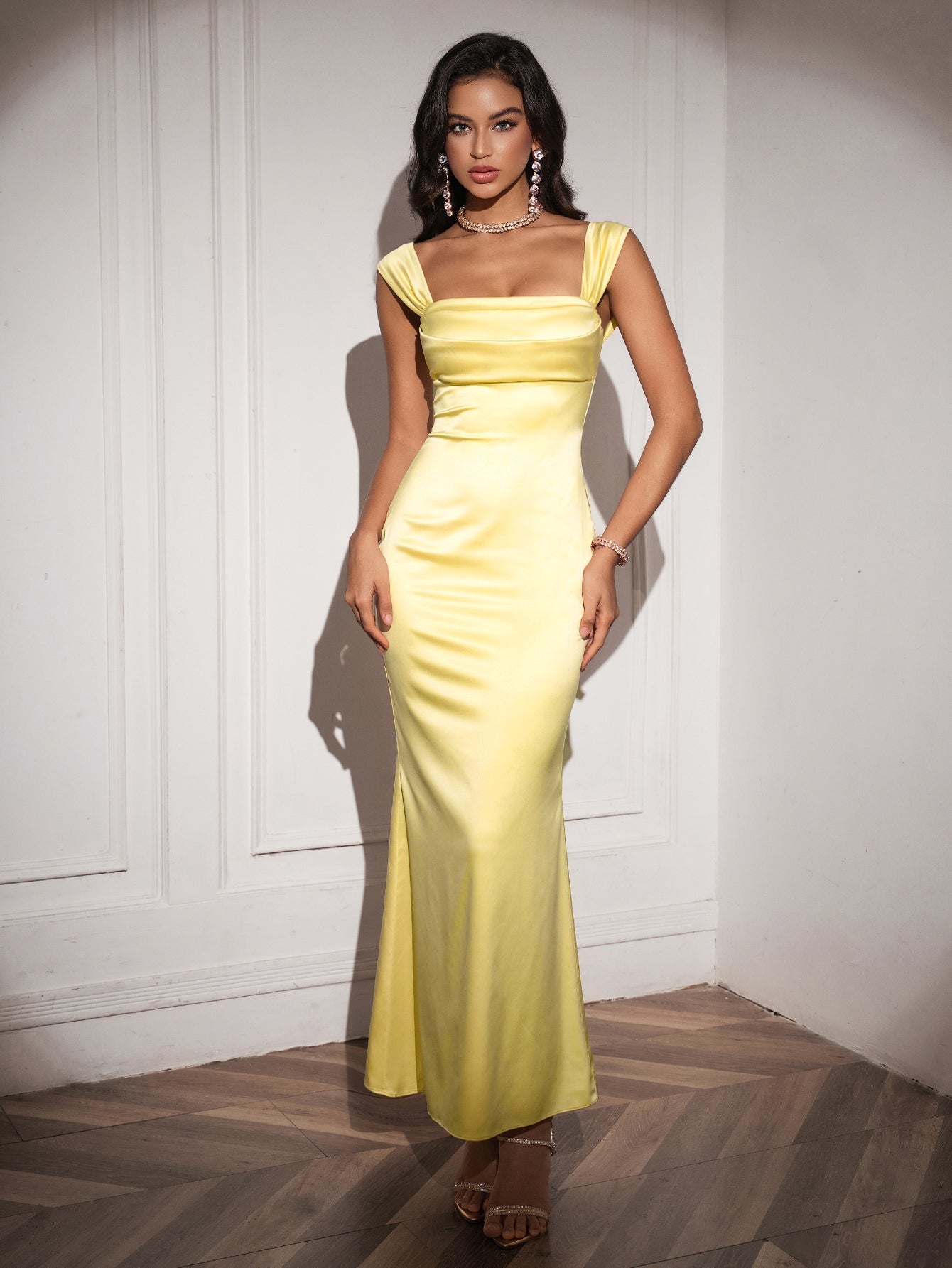 Woman showcasing a yellow satin mermaid dress with a square neckline