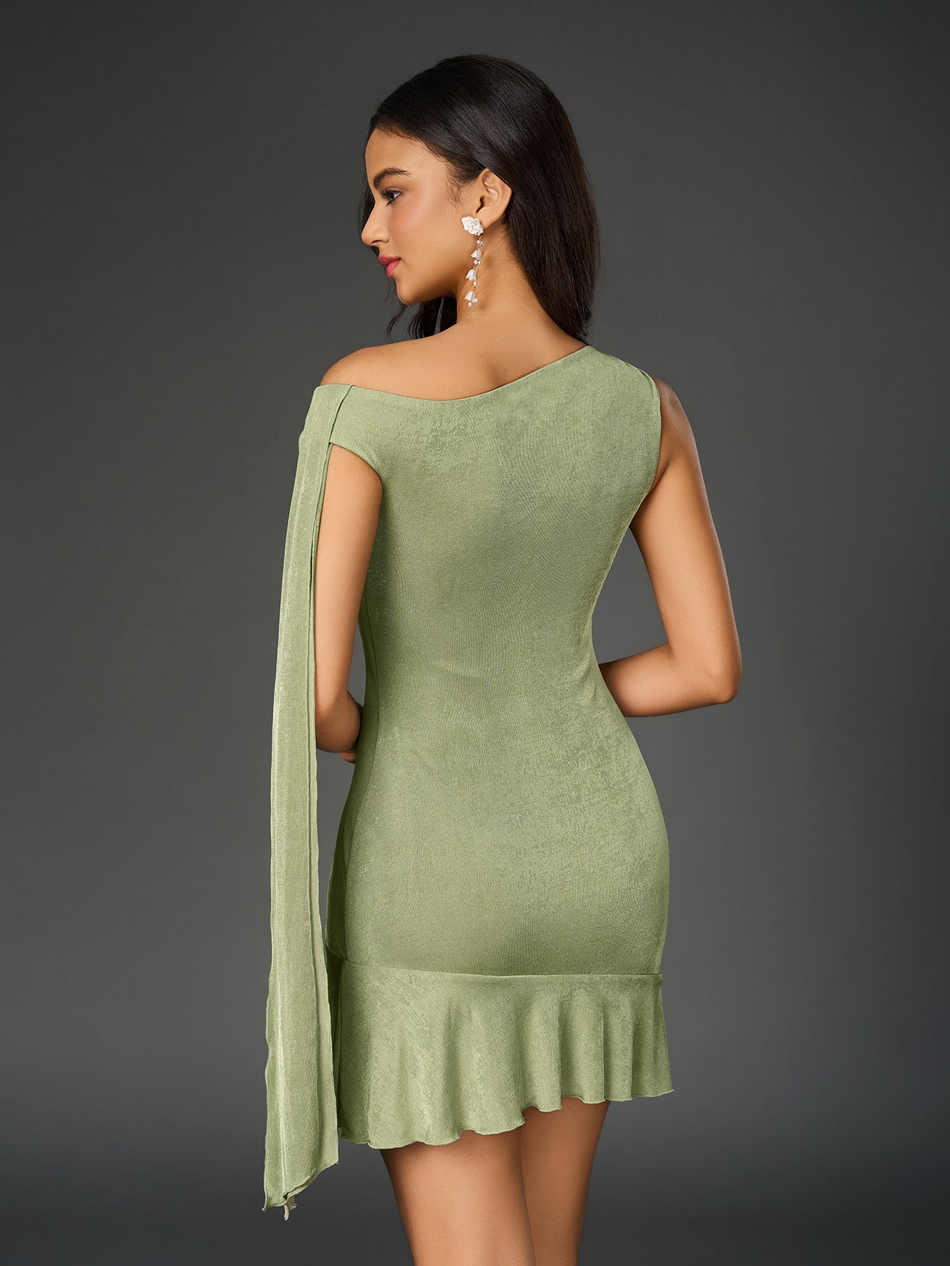 Back view of a lime green one-shoulder sheath dress with draped sleeve detail and ruffled hem.
