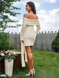 Back view of a woman in a cream off-the-shoulder long-sleeve bodycon mini dress with a tie-waist detail.