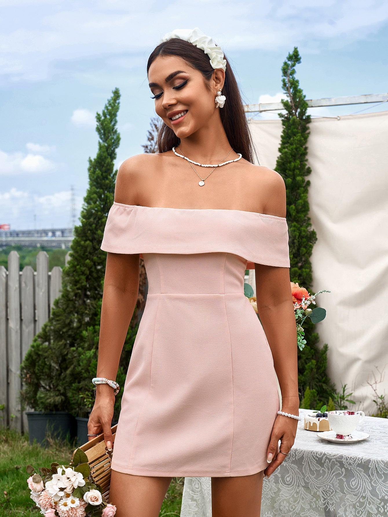 Woman wearing a pink off-the-shoulder mini dress outdoors Main image