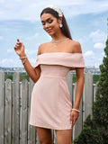 Model posing in a pink off-the-shoulder dress with a floral headband