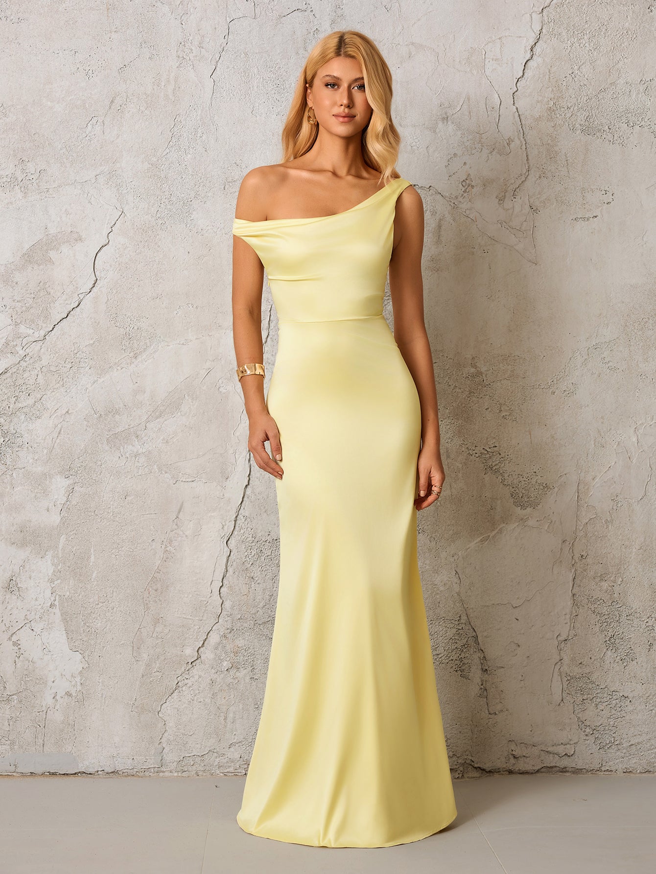 Model wearing a pale yellow satin one-shoulder floor-length gown