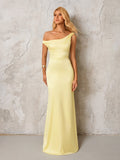 Woman posing in a pale yellow satin one-shoulder floor-length gown