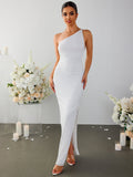Woman in a white one-shoulder textured column gown with a high slit.