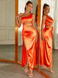 Woman in an orange satin one-shoulder maxi dress with cut-out details and a high slit.