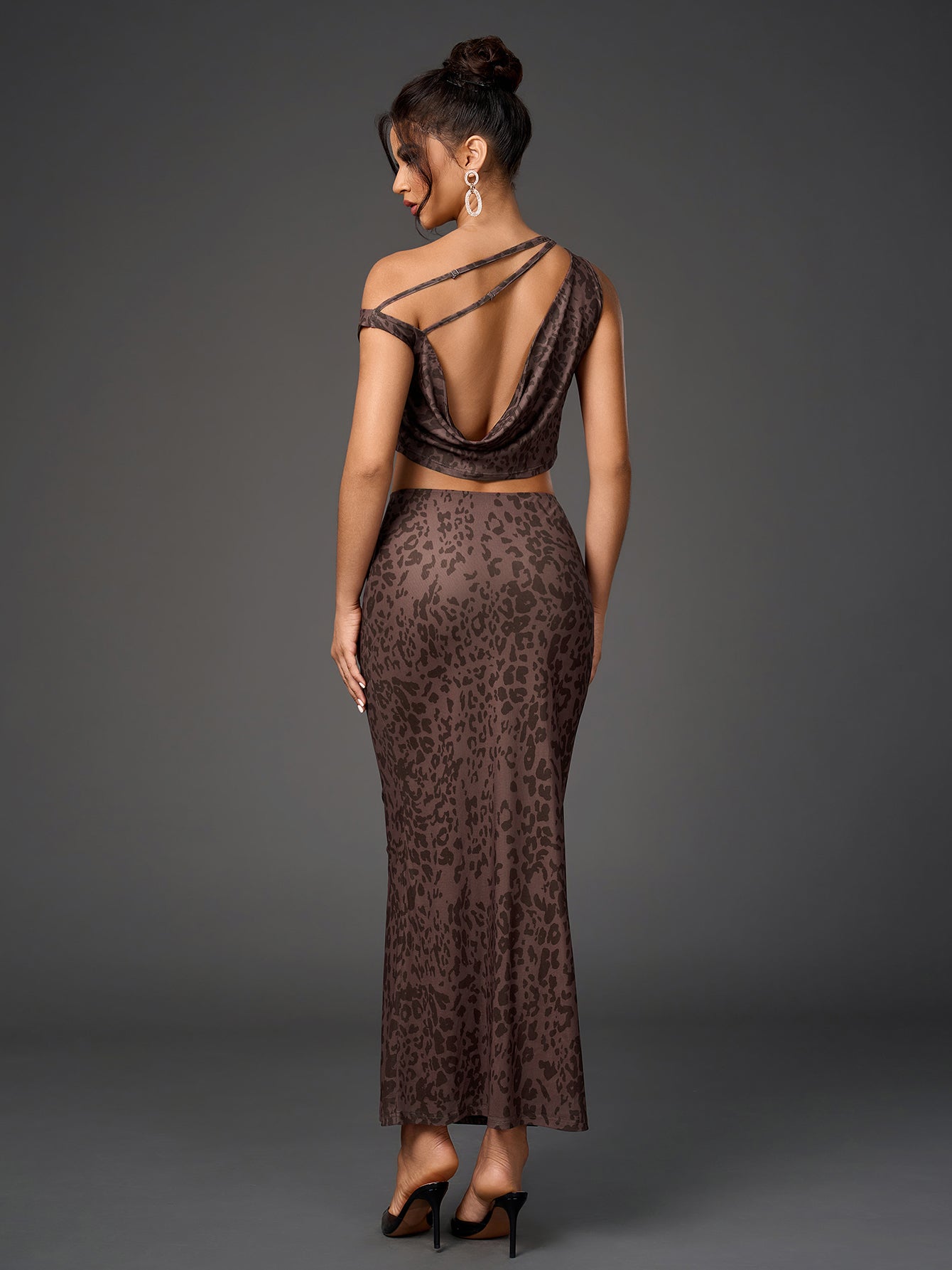 Back view of a woman in a brown leopard print sheer mesh two-piece set, showcasing an open back top and a long fitted skirt.