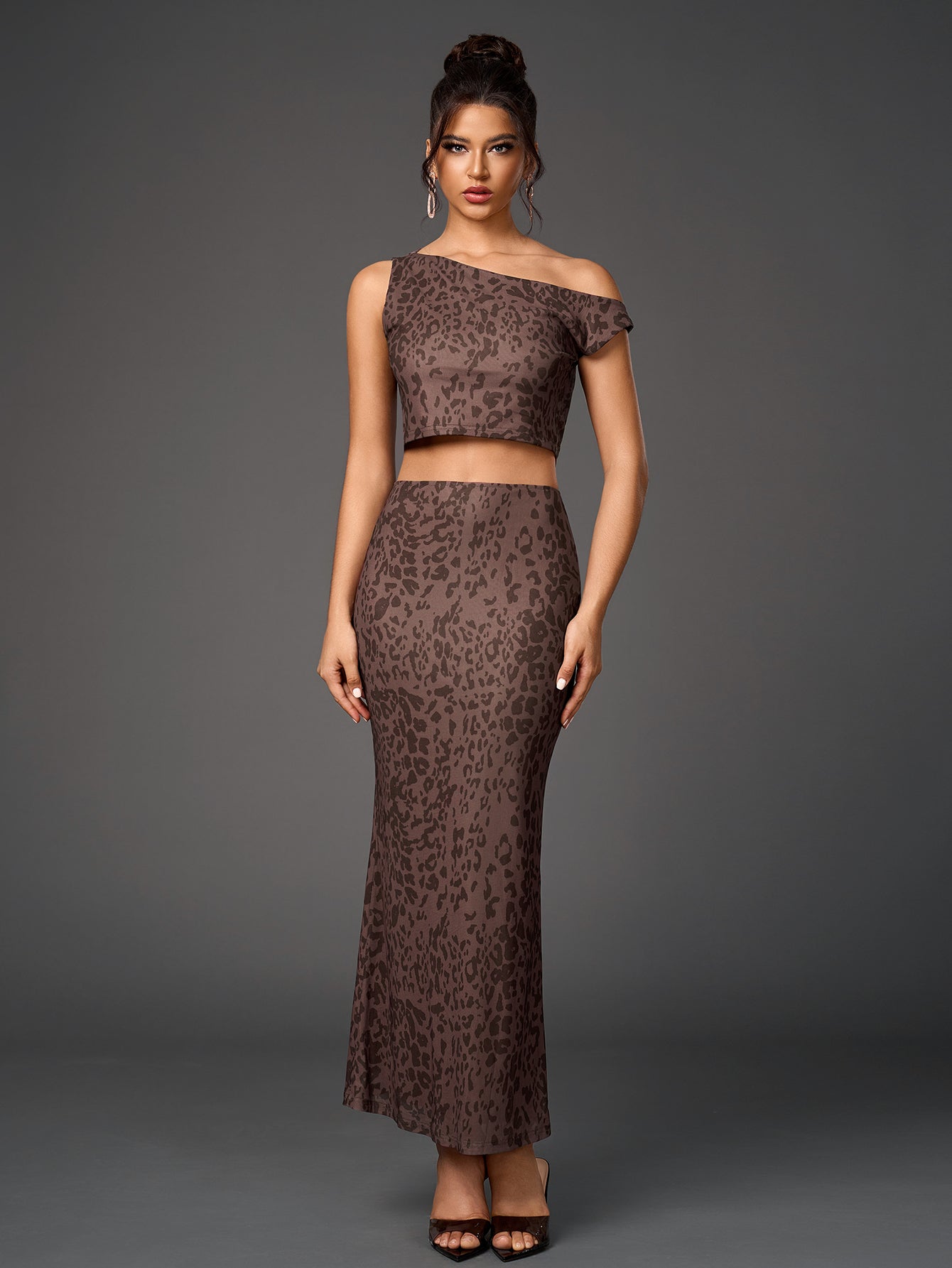 Full-body shot of a woman in a brown leopard print sheer mesh two-piece ensemble, including a one-shoulder cropped top and a floor-length skirt.