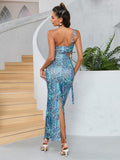 Back view of a woman in a blue abstract print strapless maxi dress with a high slit and cut-out details.