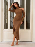 Woman in a brown one-shoulder long sleeve dress with ruching and a ruffle hem, posing with her hand on her head.