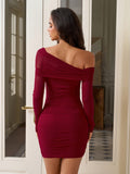 Back view of a woman in a burgundy ruched bodycon dress with an asymmetrical neckline