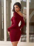 Woman posing in a burgundy ruched off-the-shoulder dress, showing off the back detail