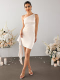 Full body shot of a woman in a cream one-shoulder satin sheath dress.