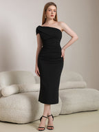 Woman wearing a black one-shoulder ruched sheath dress