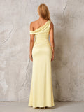 Back view of a woman in a pale yellow satin one-shoulder floor-length column dress