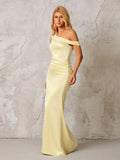 Side view of a woman in a pale yellow satin one-shoulder floor-length column dress with draping and ruching